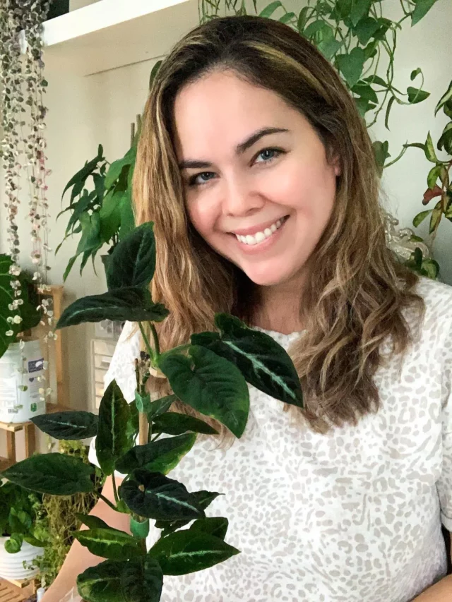 Happy Woman Taking Photo with Syngonium Rayii Plant at Home Garden Area